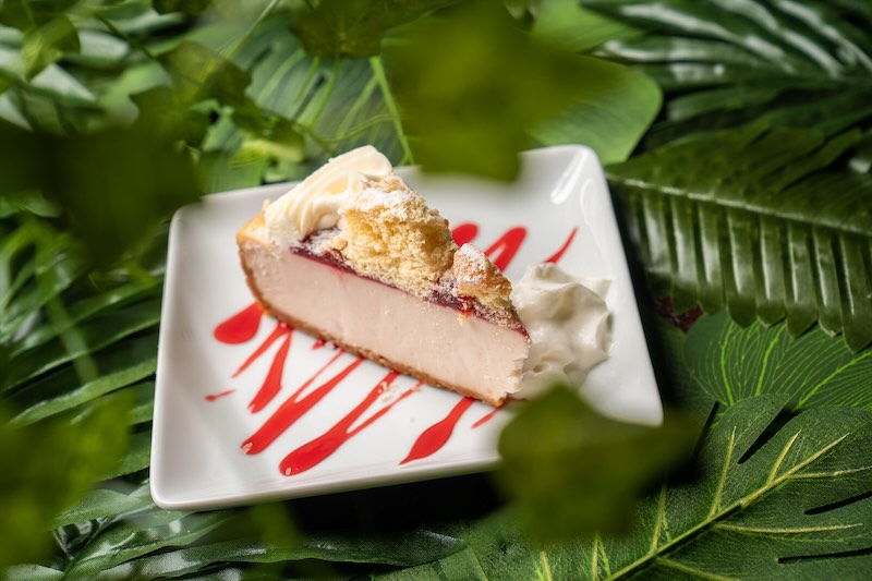a cheesecake on a plate among leaves