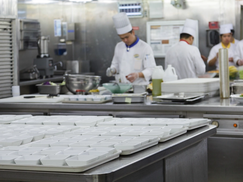 A commercial kitchen with chefs in it